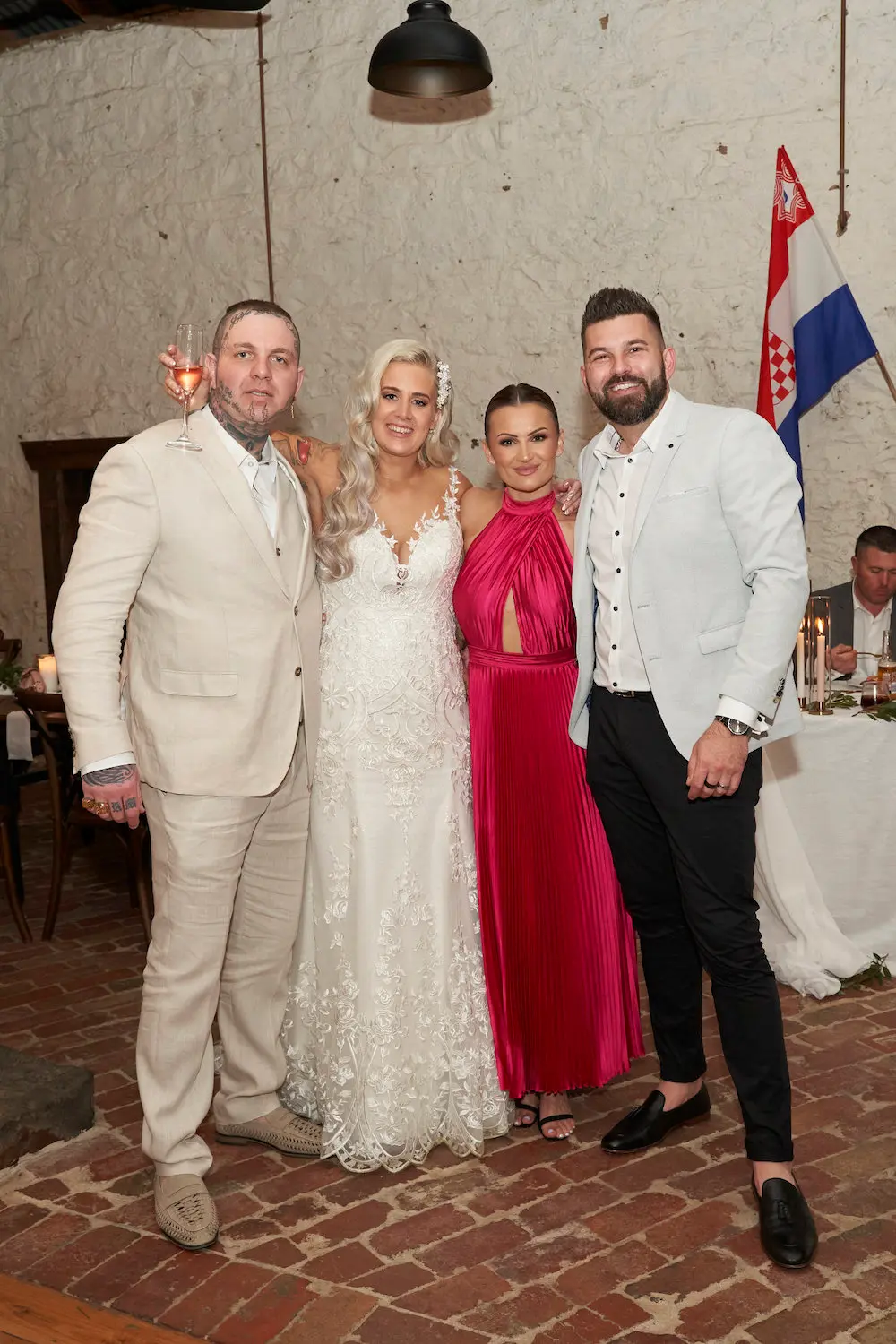 bride groom with guests champagne wedding reception Bride and groom smiling with wedding guests during the reception, bride holding a glass of champagne