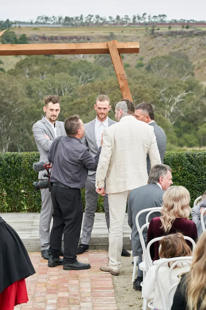 darko groomsmen warrawong estate wedding ceremony candid Groom Darko and his groomsmen chatting with the videographer while waiting for the bride at their Warrawong Estate wedding ceremony, with the scenic valley and countryside visible in the background