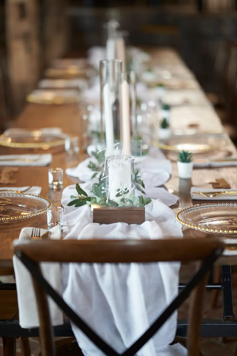emma darko warrawong estate wedding reception decoration table closeup Close-up of wedding table decoration at Emma and Darko’s Warrawong Estate reception, featuring table settings, candles, and rustic decorative leaves illuminated by natural light