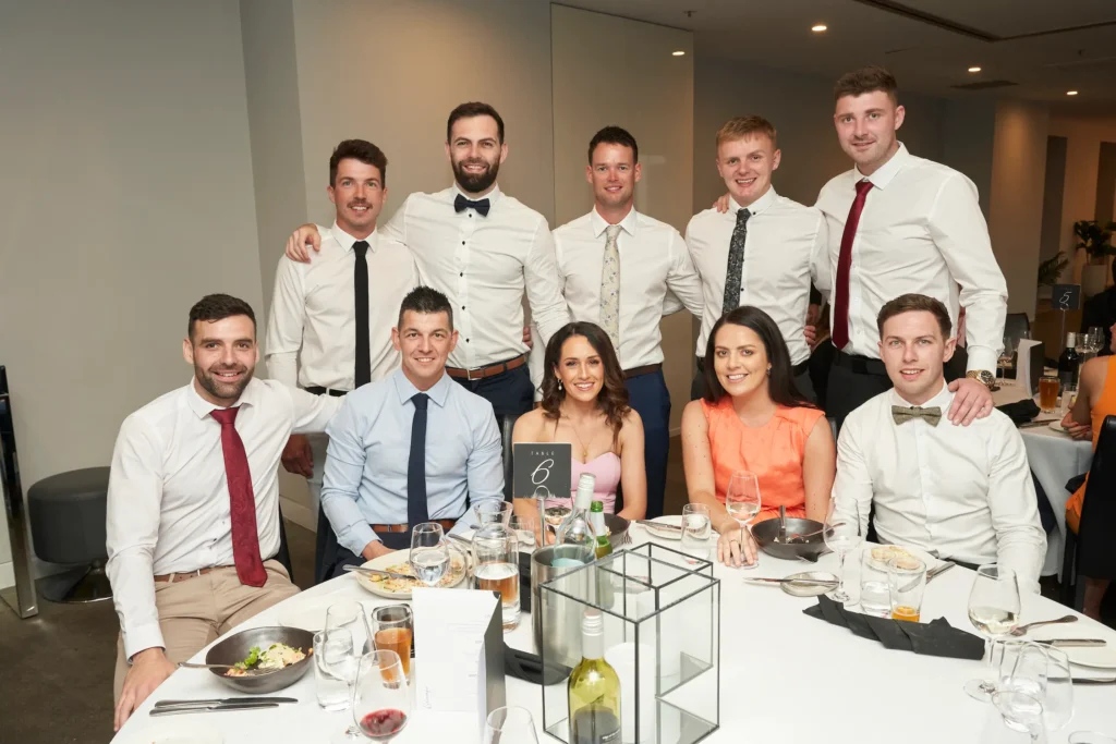 svg%3E Group of guests smiling at their table during the Garryowen Awards Night dinner, captured just before the awards presentation
