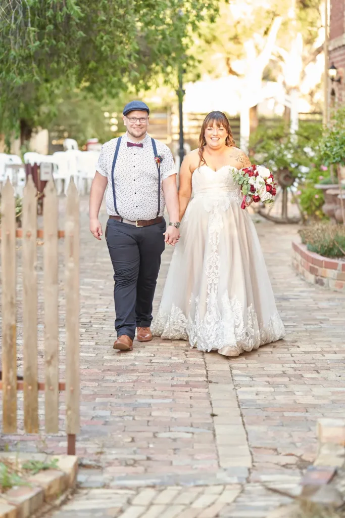 Bride and groom holding hands and walking near sunset with bouquet at Bendigo Pottery function centre