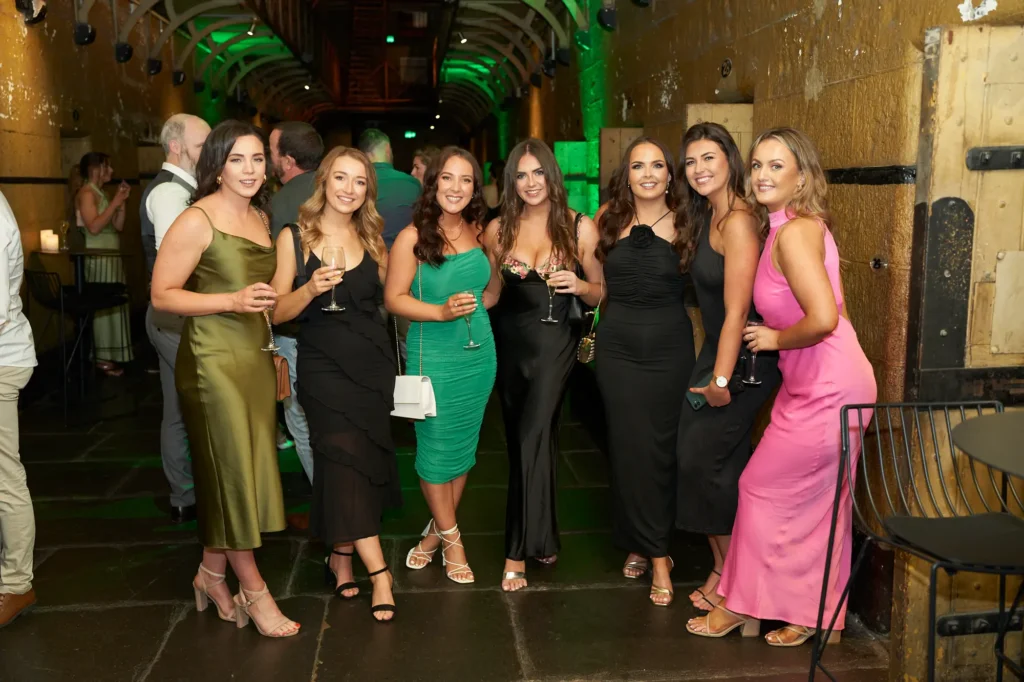Seven guests posing for a group portrait at a Melbourne awards night and gala dinner inside a historic venue with elegant evening attire.