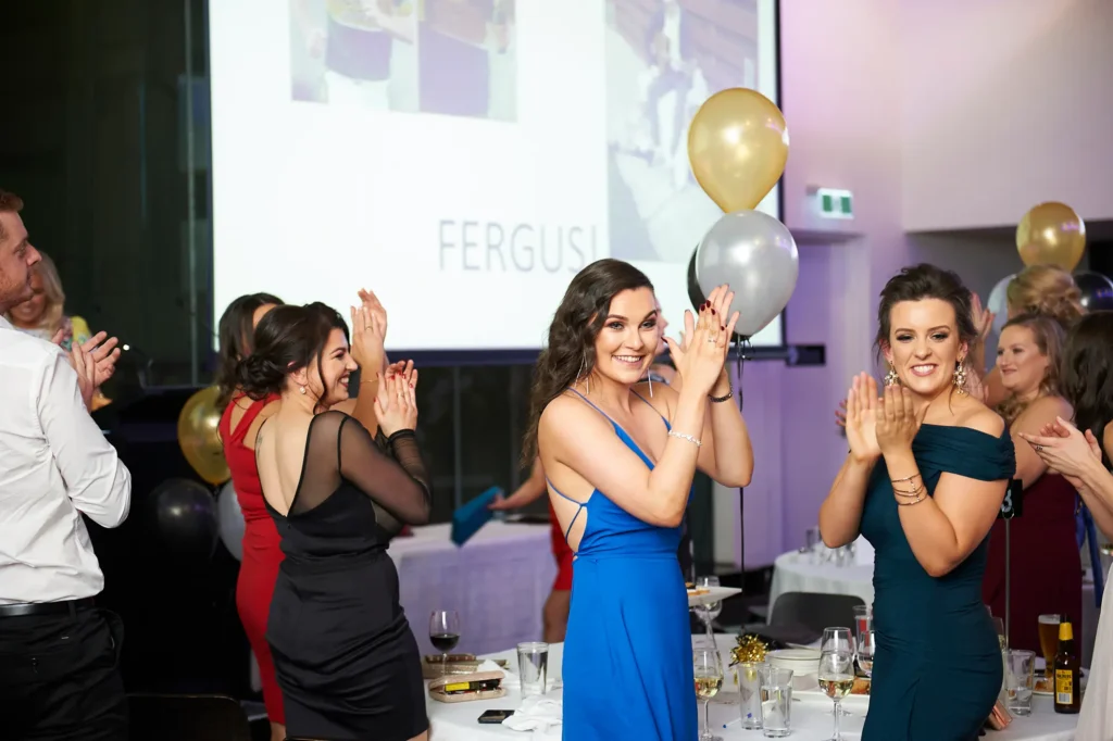 Guests standing and applauding during an award presentation at a Melbourne awards night and gala dinner celebration.