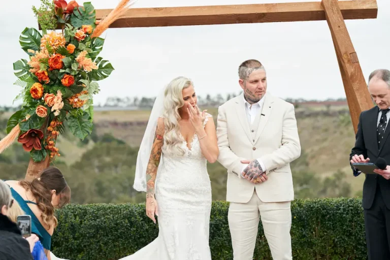 Bride Emma wiping a tear from her face during her wedding ceremony at Warrawong Estate, captured in an emotional, candid moment