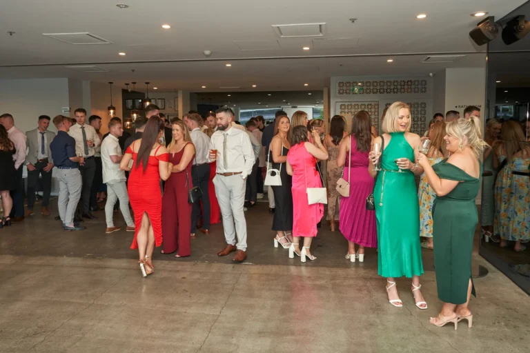 Wide shot of guests socializing and holding drinks at River’s Edge Events during the Garryowen Awards Night, showing a well-dressed crowd in a spacious indoor setting